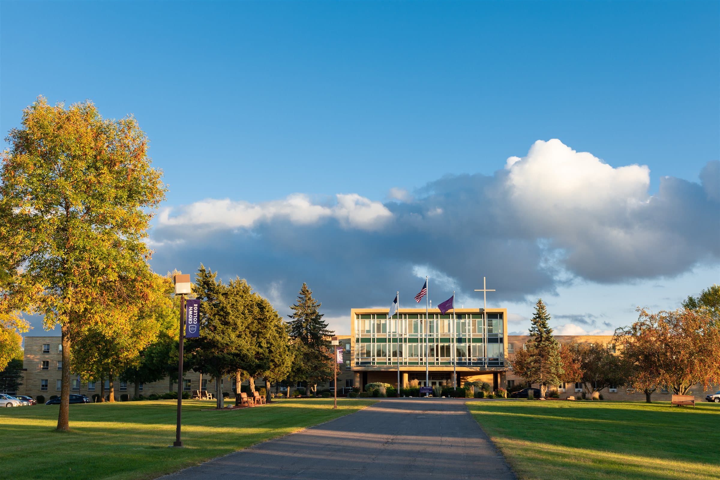 A college campus quad in autumn, golden trees against a blue sky